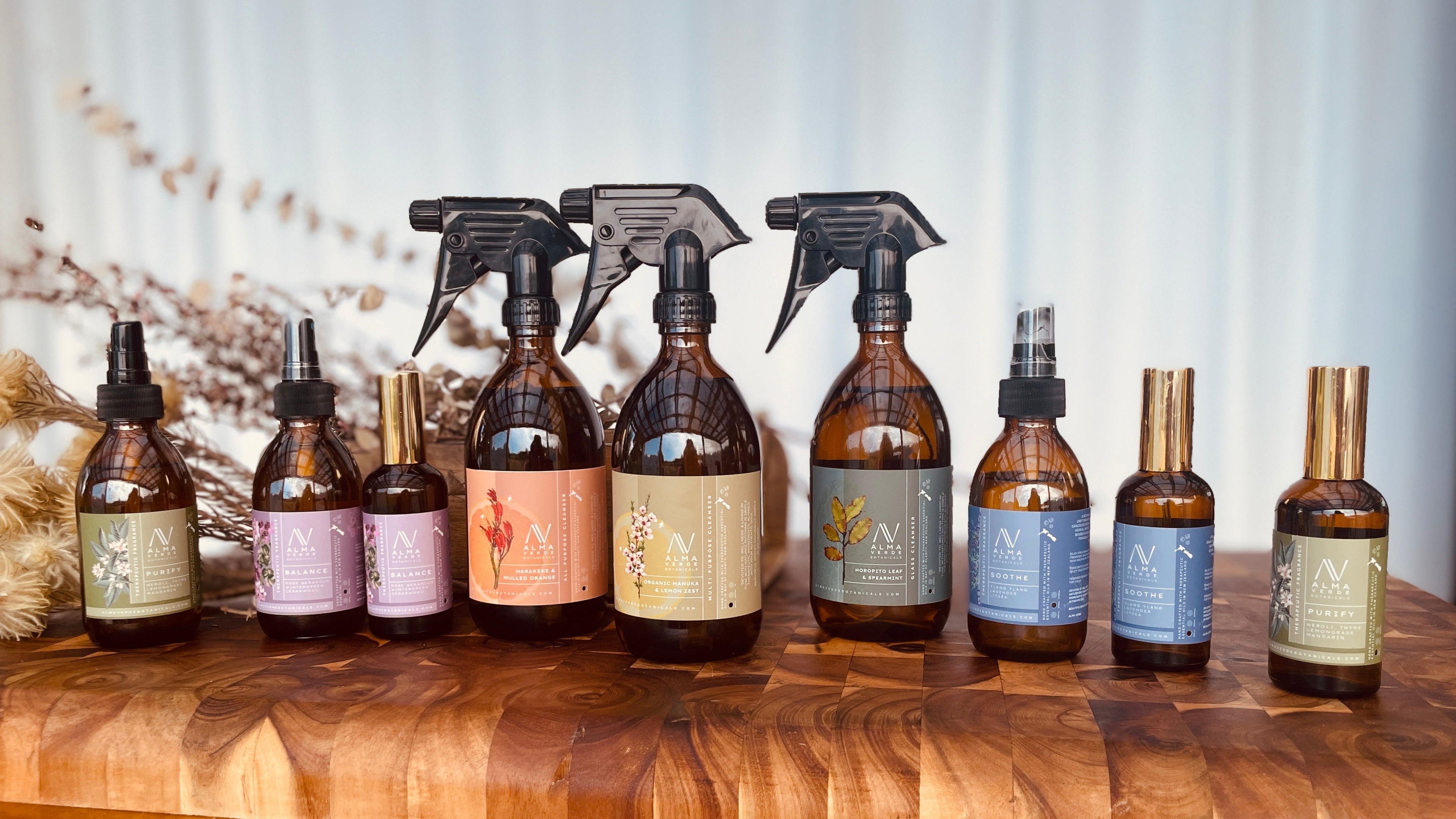 Set of various bottles and spray bottles on a wooden surface with a neutral background